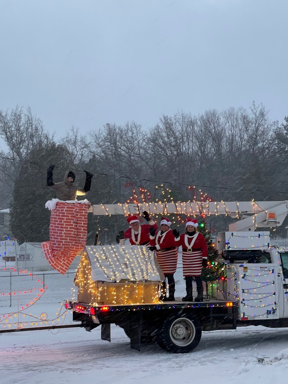 Santa’s boots, Maggie Jo Ware in the chimney, is
joined by Santa’s elves, Tracey Wheeler-Clay, Kathy
Maharas, and Tracey Connelly on one of the several
City of Harrison parade vehicles. (